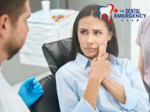 Woman at dental clinic holding her jaw in pain, consulting dentist about toothaches