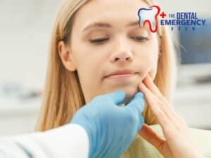 Dentist examines young woman’s jaw as she experiences toothaches